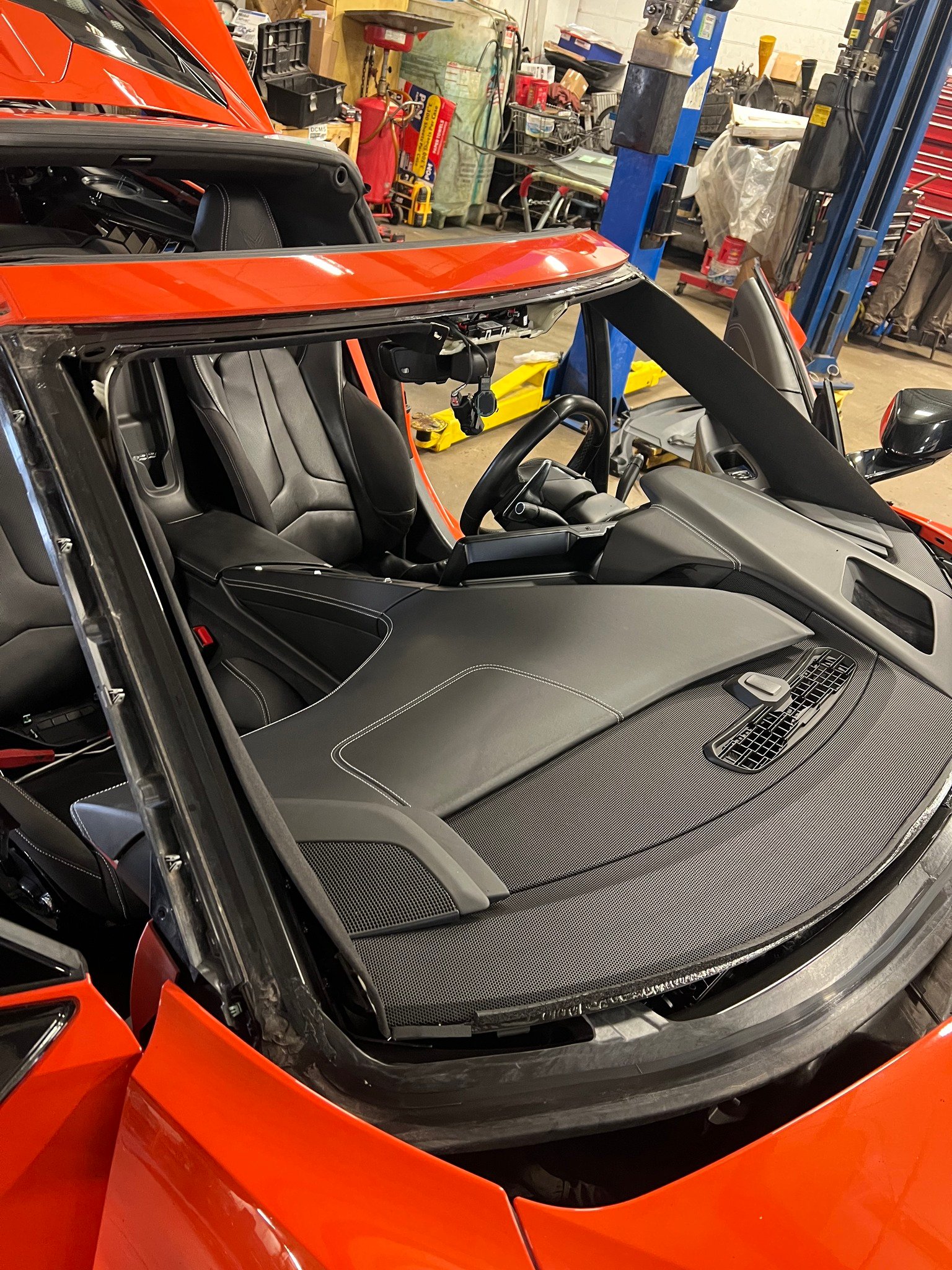 Orange Corvette C8 interior with windshield removed during replacement at B-Rite